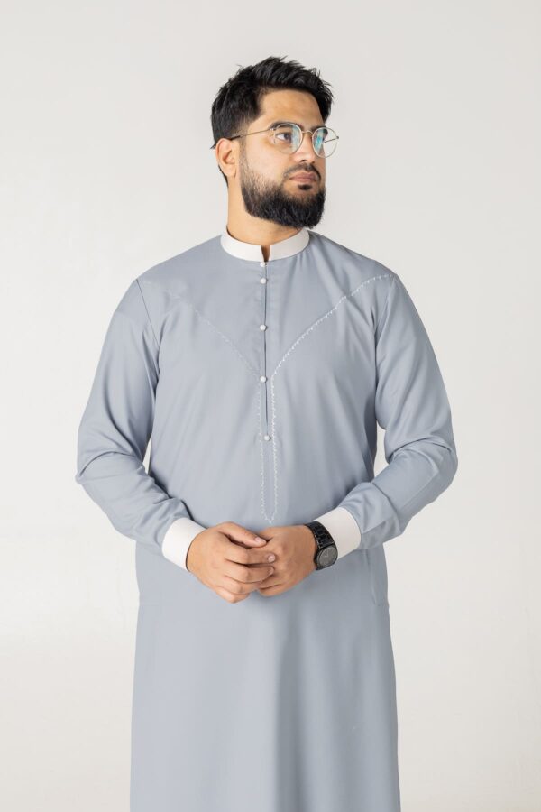 Steel grey and black contrast thobe by alqamees. Features a textured collar and embroidered placket for a modern, sophisticated style.