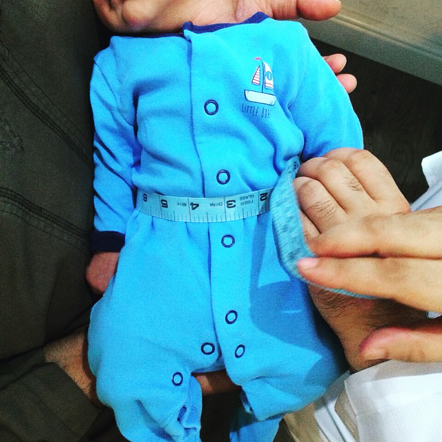 Precision tailoring for infants at alqamees. A demonstration of the detailed measurement process used to ensure a perfect fit for even the youngest customers.