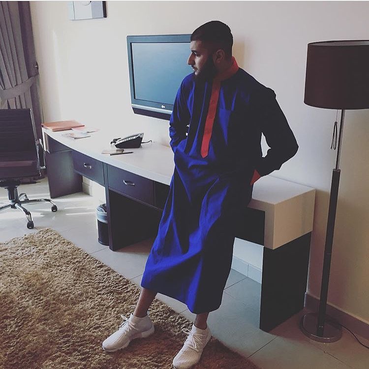 Modern custom thobe design in royal blue and orange. A lifestyle shot of an al qamees DYO garment showcasing contemporary styling with sneakers.