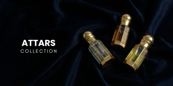 Premium Attar Collection featuring three ornate gold-capped glass perfume oil bottles with intricate filigree designs on a luxurious dark navy velvet fabric.