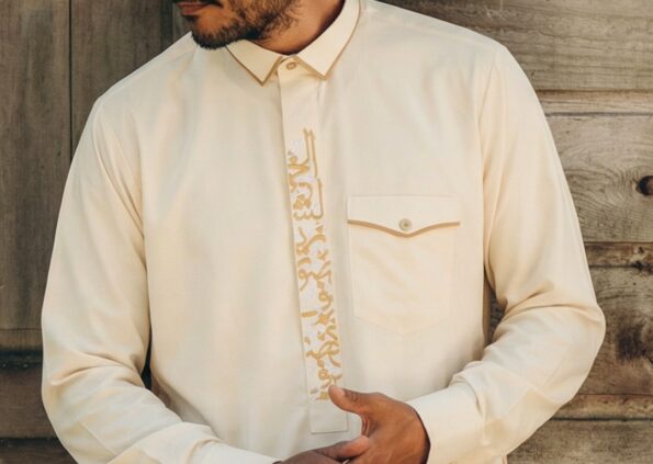 Close-up of hand-stitched collar and button details on a custom qamees
