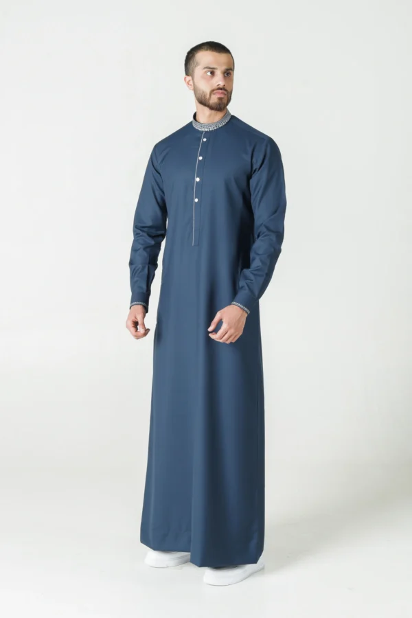 Men’s olive green thobe with tonal embroidery by alqamees. This ready-to-wear thobe features a tailored fit, a mandarin collar, and signature geometric detailing on the placket and cuffs. A versatile piece from the alqamees collection suitable for both formal and casual settings.
