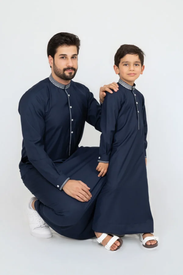 Boys navy blue thobe with white button placket and silver geometric embroidery on the collar and cuffs, elegant kids' jubba from alqamees.