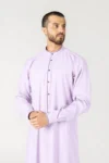 Man wearing a lavender thobe with purple piping, standing against a light background and looking to the right.