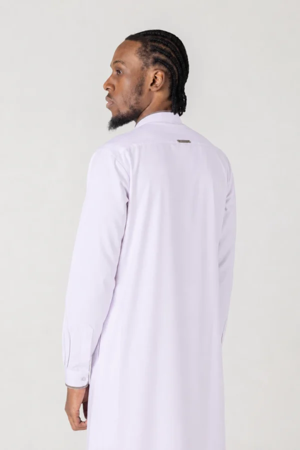 Man with cornrows wearing a pale lavender long-sleeve shirt, viewed from behind against a neutral backdrop.] ,