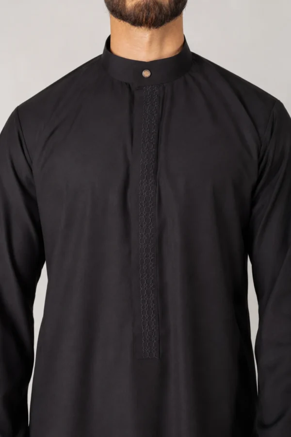 Close-up of a person wearing a black kurta with a textured vertical placket and mandarin collar.