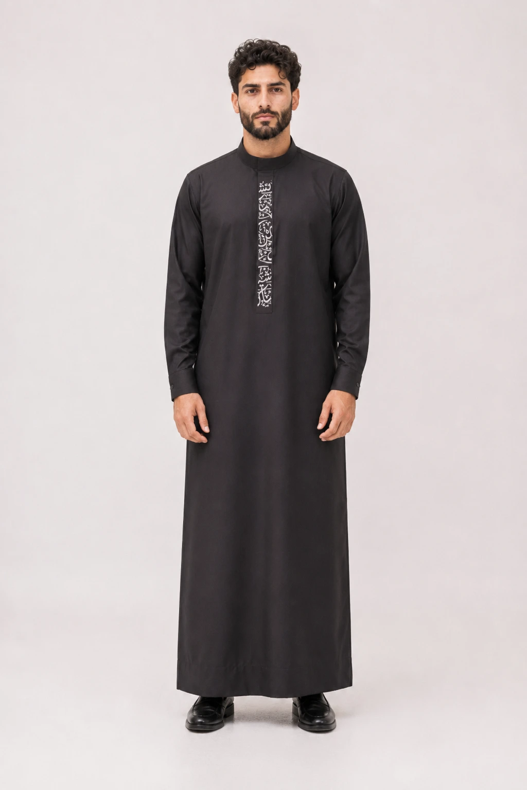 Backhour Black Full-body shot of a man wearing a black thobe with white vertical embroidery down the front, standing against a neutral backdrop.