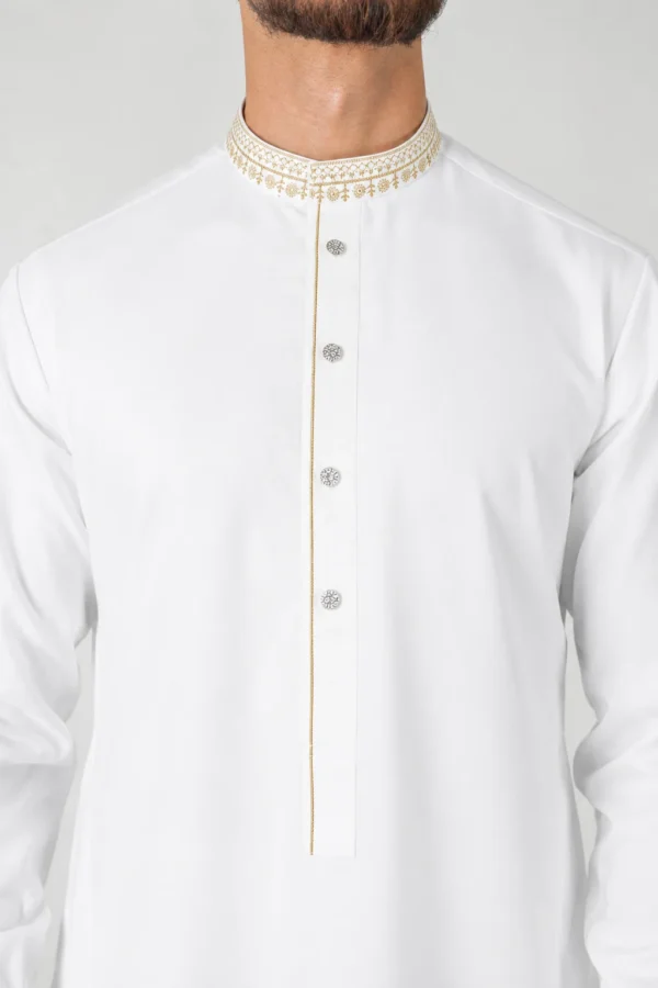 White traditional kurta with a gold-embroidered mandarin collar and decorative silver buttons along a placket with a thin gold trim.