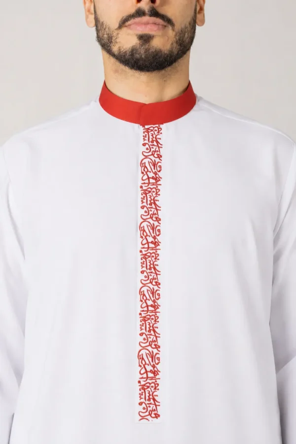 Man wearing a white traditional tunic with a red mandarin collar and red embroidered placket down the front.