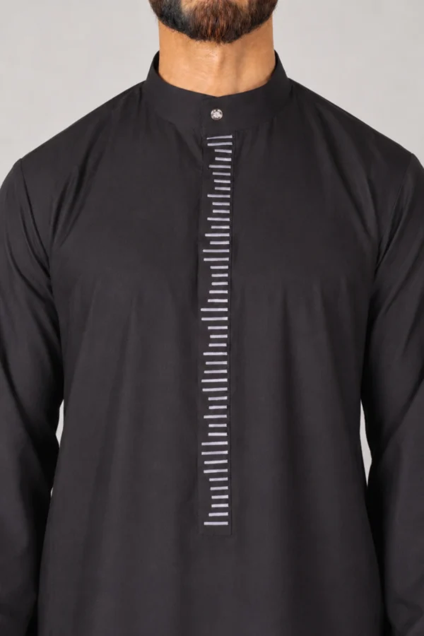 Man wearing a black kurta with a mandarin collar and a vertical placket adorned with white horizontal stripes.