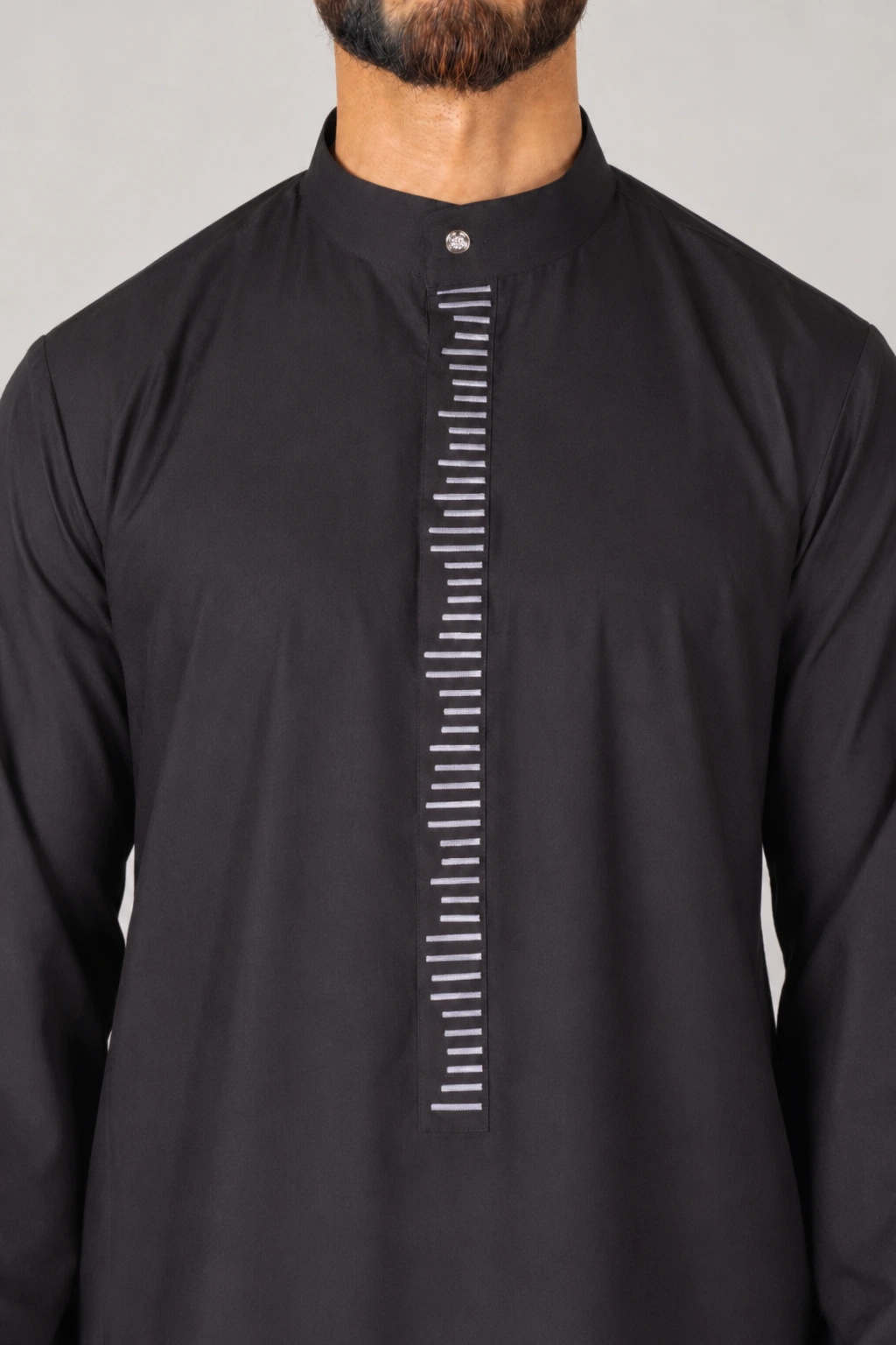 Rasasi Black Edition (4) Man wearing a black kurta with a mandarin collar and a vertical placket adorned with white horizontal stripes.