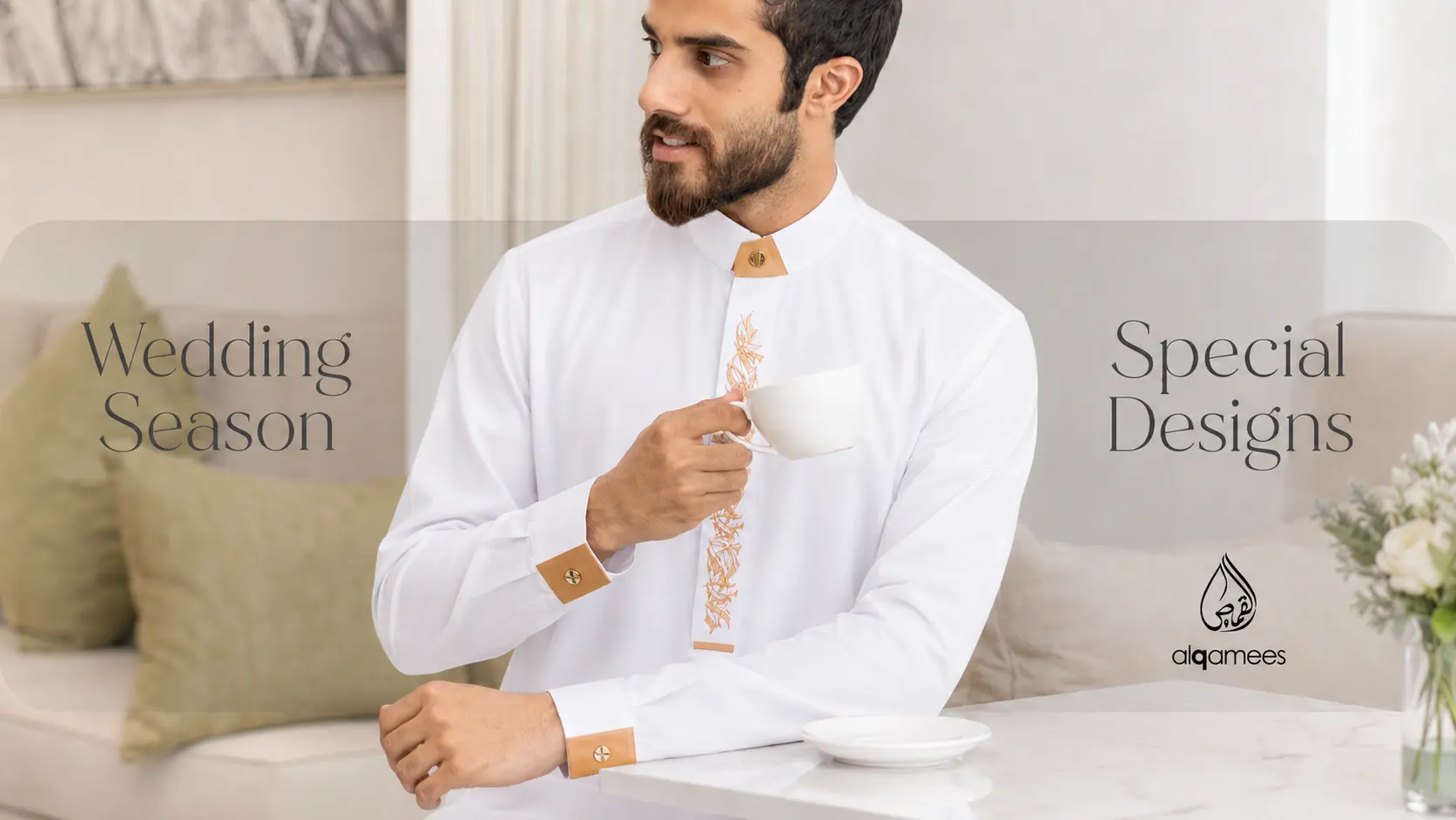 Man in a white traditional thobe with peach cuffs and embroidery sits at a marble table, holding a teacup, with soft branding text reading 'Wedding Season' and 'Special Designs' in the background (Alqamees).